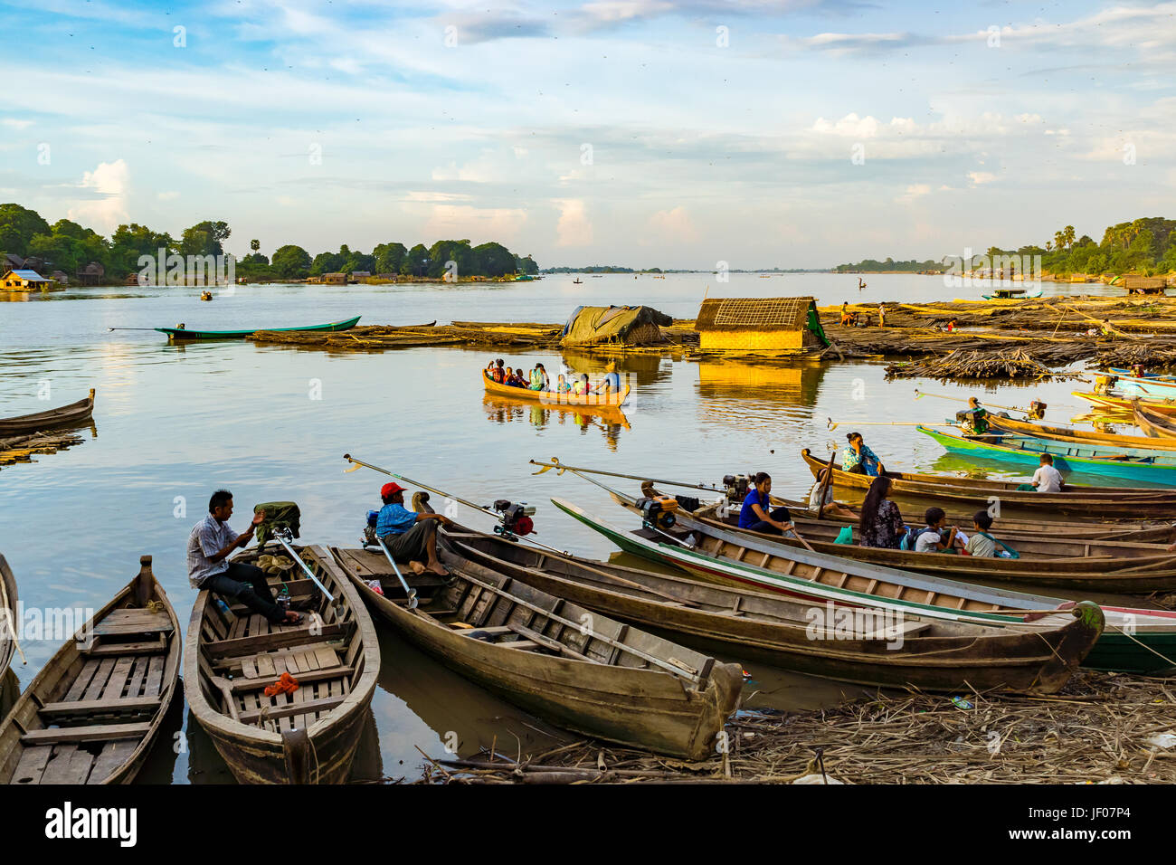 Ayeyarwaddy river, Mandalay, Myanmar. Early evening and moored boats are ready to take the city workers back across the great river. Stock Photo