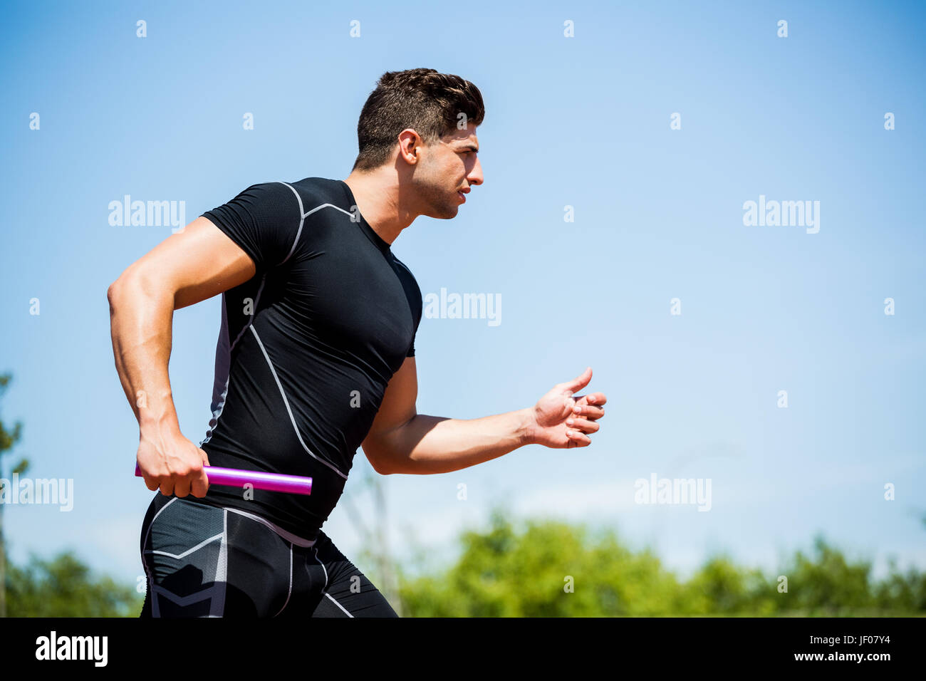 Relay athlete running with baton Stock Photo