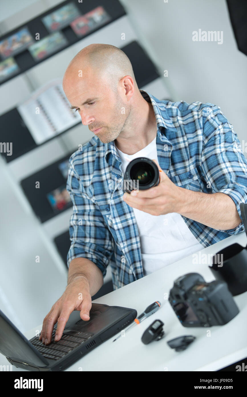 photographer checking how to clean camera online Stock Photo
