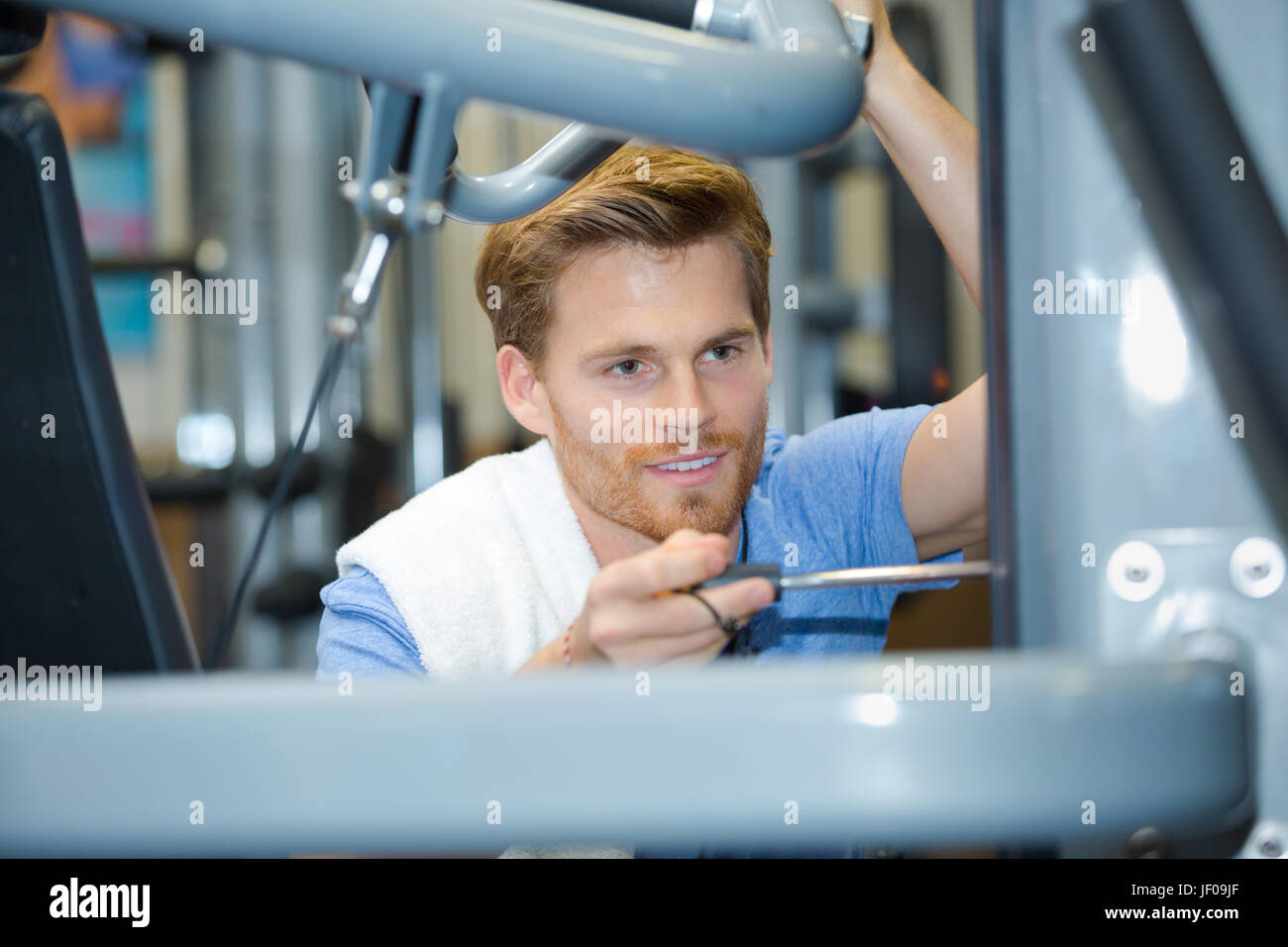 man setting up fitness equipment in gym Stock Photo Alamy