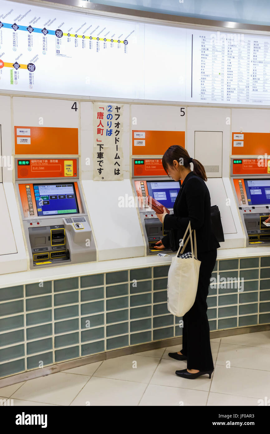 Fukuoka, Japan - November 14 2013: Unidentified woman buys ticket from vending machine at Hakata Station Stock Photo
