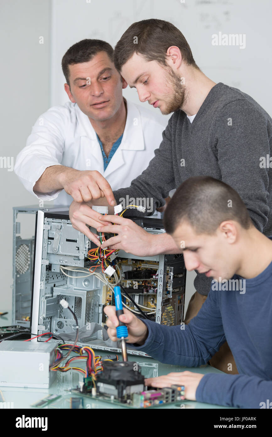 Young men working on dismantled computer Stock Photo - Alamy