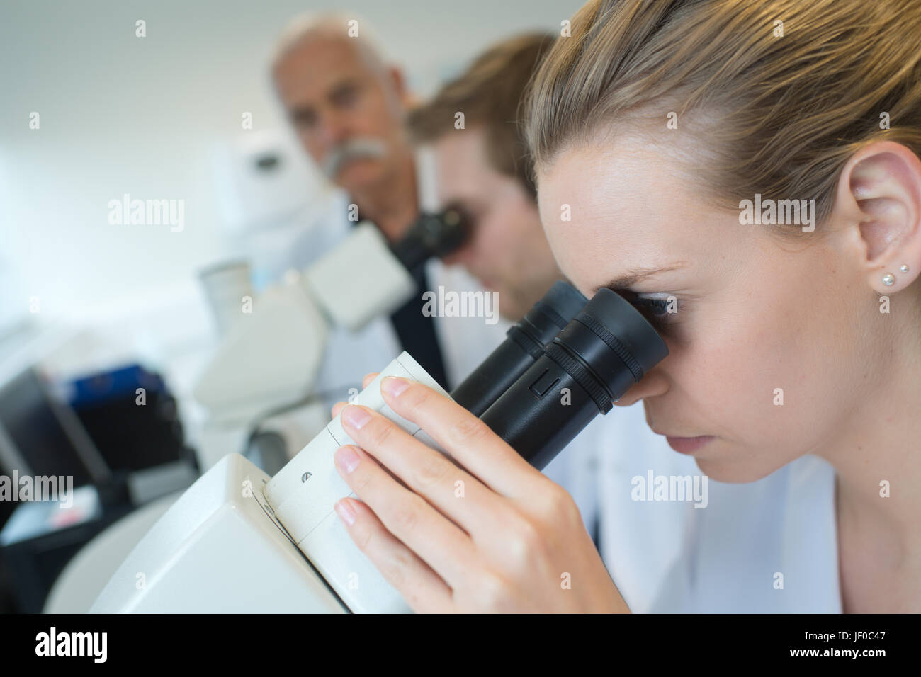 Woman looking into microscope Stock Photo Alamy