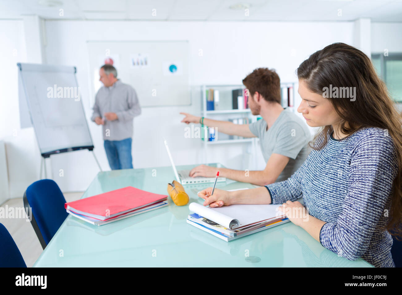 Class in progress, teacher stood by flip chart Stock Photo