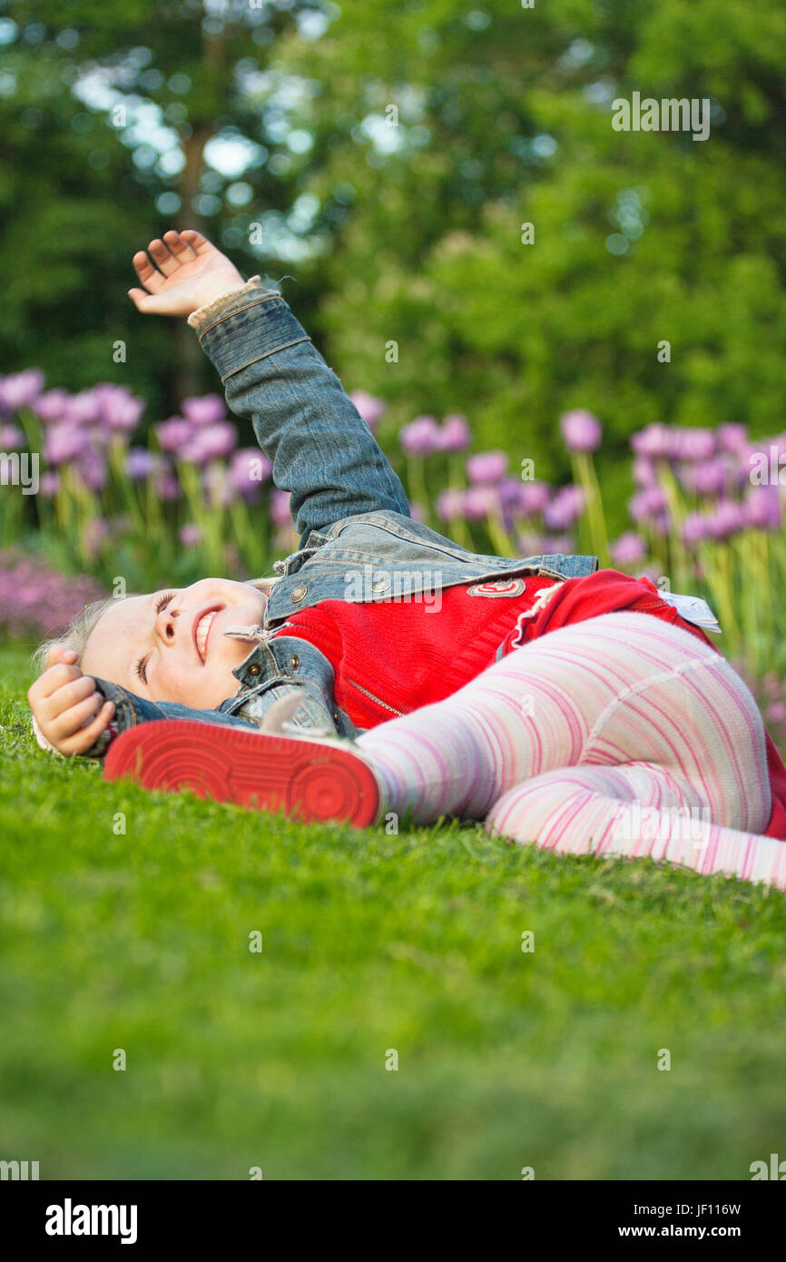 Little girl playing on grass Stock Photo - Alamy