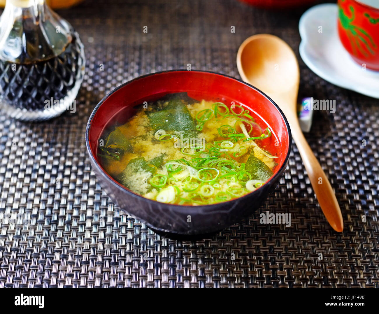 A closeup of a steaming bowl of Japanese miso soup from above, against a dark background. Stock Photo