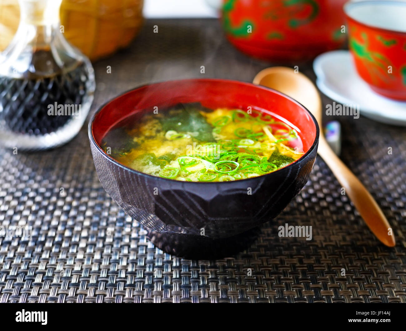 A closeup of a steaming bowl of Japanese miso soup against a dark background. Stock Photo