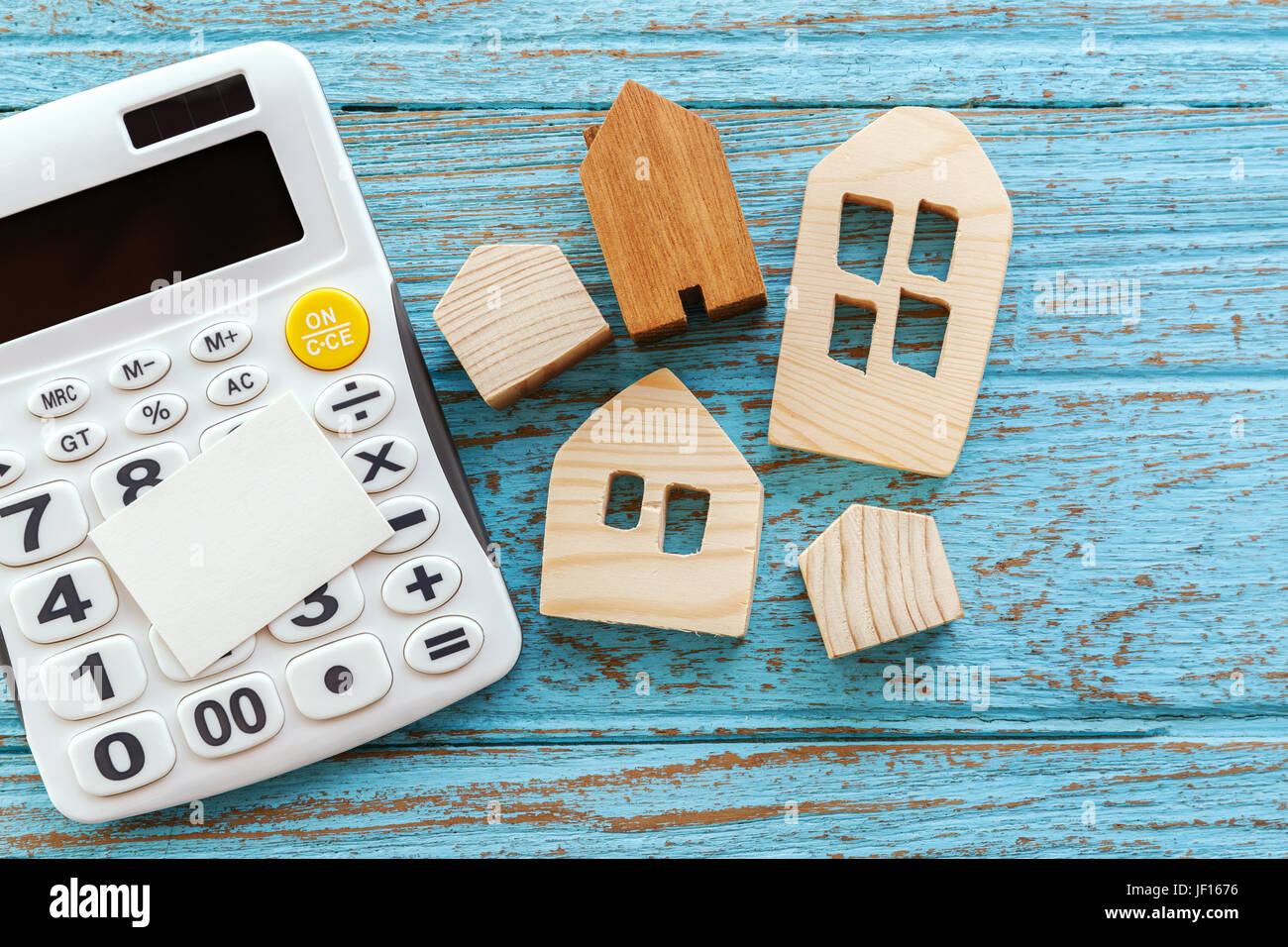 Wood houses and calculator with blank card for housing loan concept Stock Photo