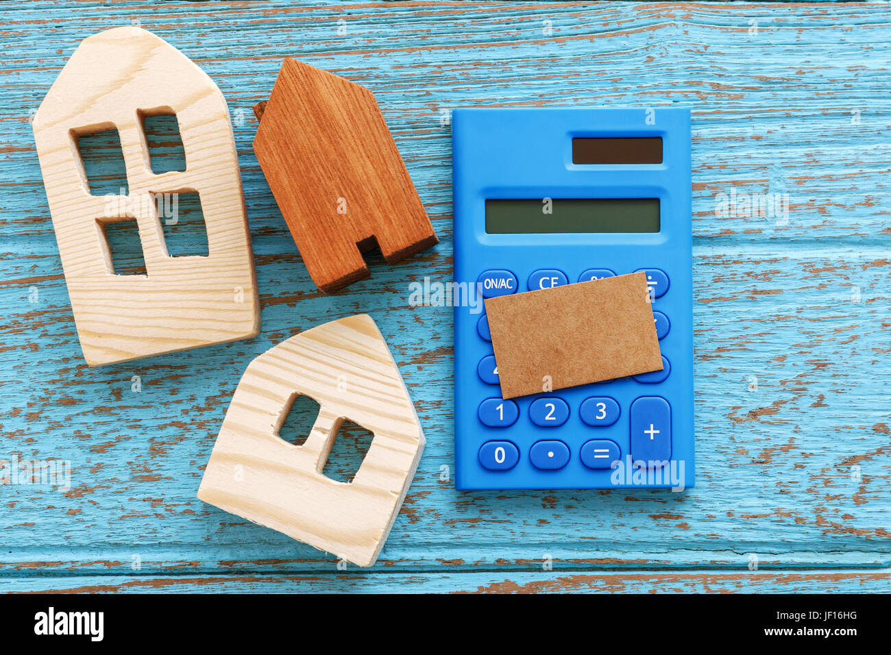 Wood house and calculator with blank card for housing loan concept Stock Photo