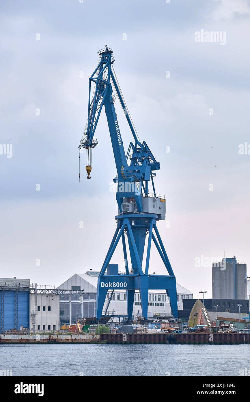 AARHUS, DENMARK - JUNE 05, 2016: Gantry crane standing on the quay at Aarhus Harbor in front of warehouse buildings Stock Photo