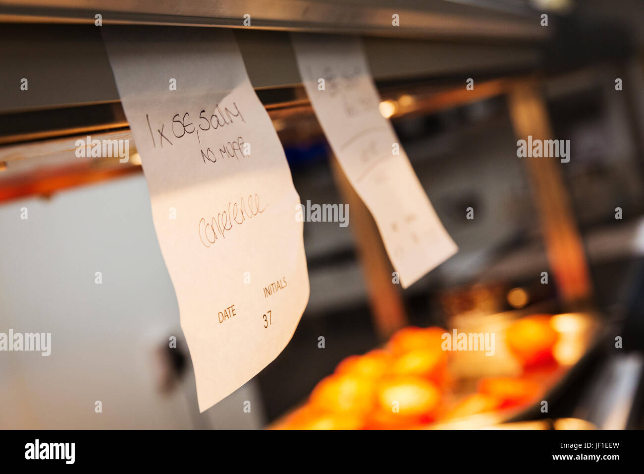 Close up of handwritten order tabs in a restaurant kitchen Stock Photo