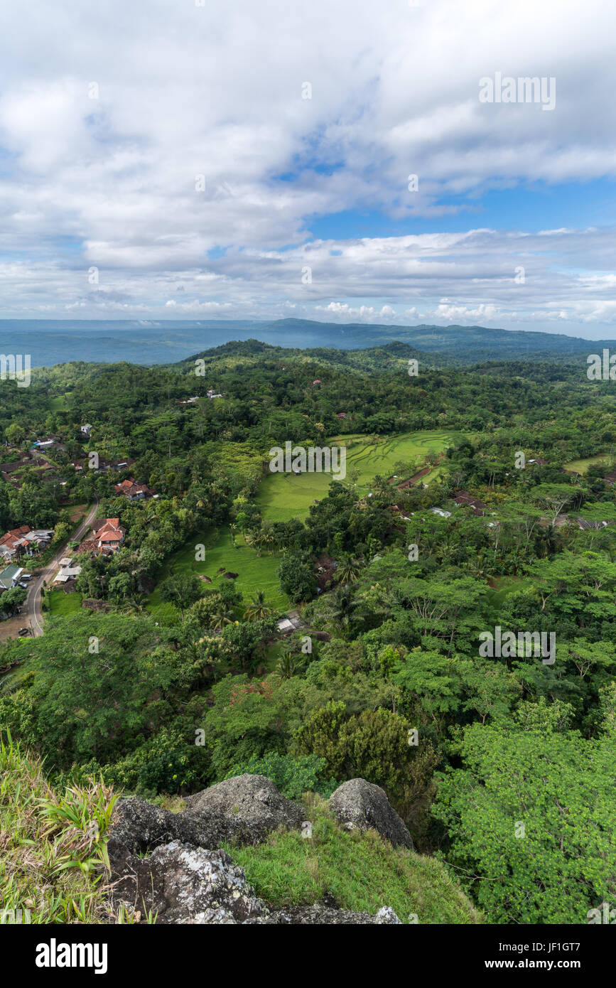 Privileged hilltop view of Indonesian countryside, with small villages, rice terraces and paddies surrounded by lush vegetation. Stock Photo