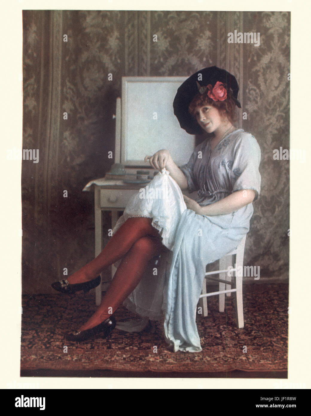 Edwardian woman showing petticoats and red stockings, c. 1912 Stock Photo