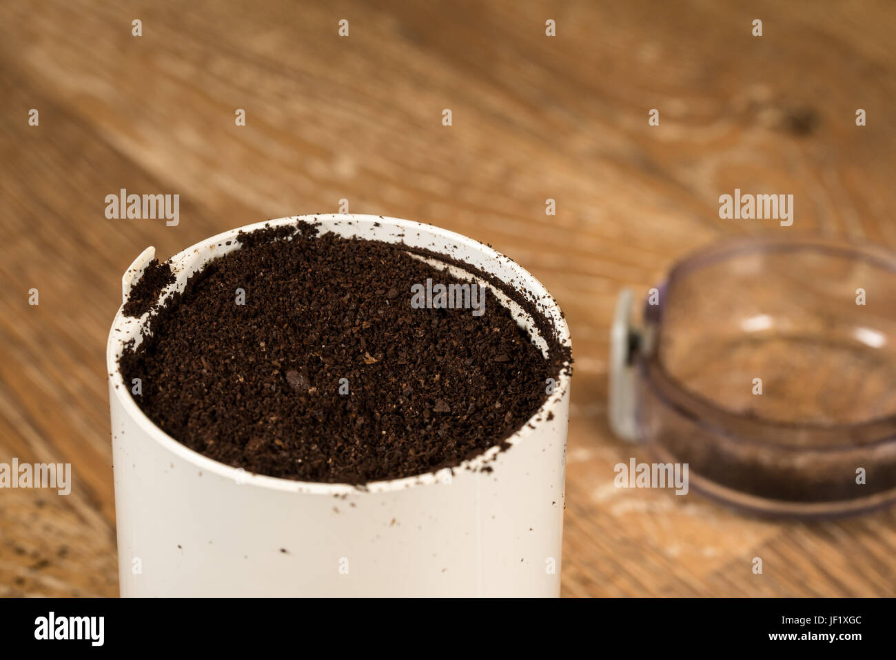Ground coffee in grinder on wooden table Stock Photo Alamy