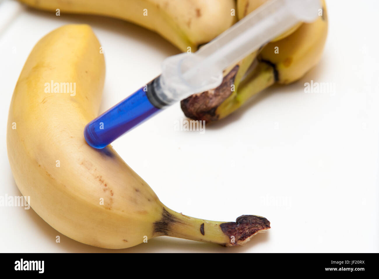 Gm food concept, additives and chemicals being injected into fruit Stock Photo