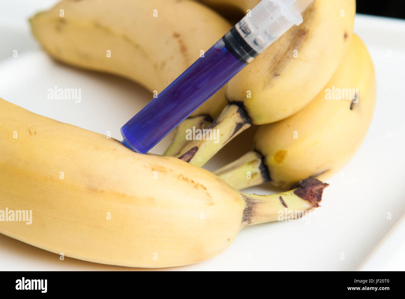 Gm food concept, additives and chemicals being injected into fruit Stock Photo
