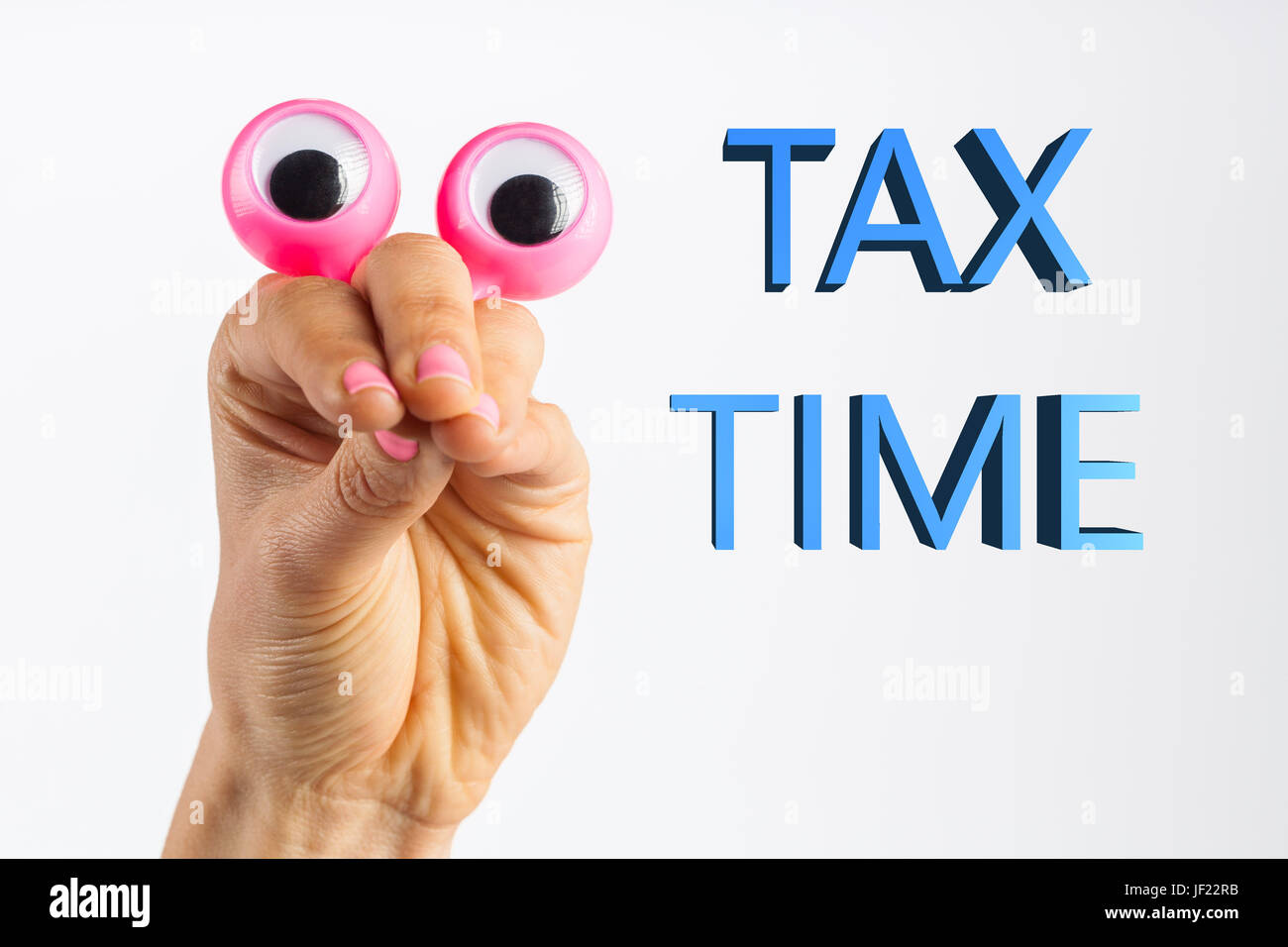 Funny character creature looking surprised and and trying to intimidate the viewer with words Tax Time. Depicted with female hand and googly eyes. Iso Stock Photo