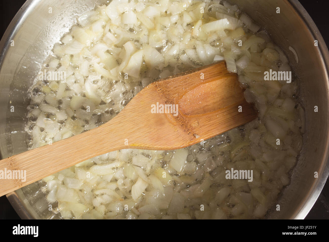 Frying onion in a pan Stock Photo