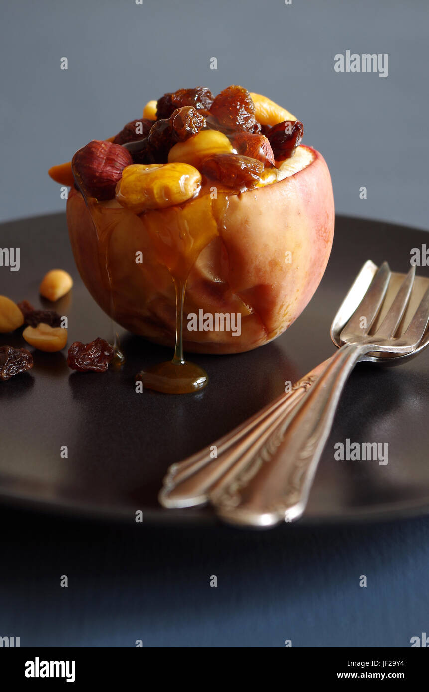 baked apple with nuts, raisins and honey Stock Photo - Alamy