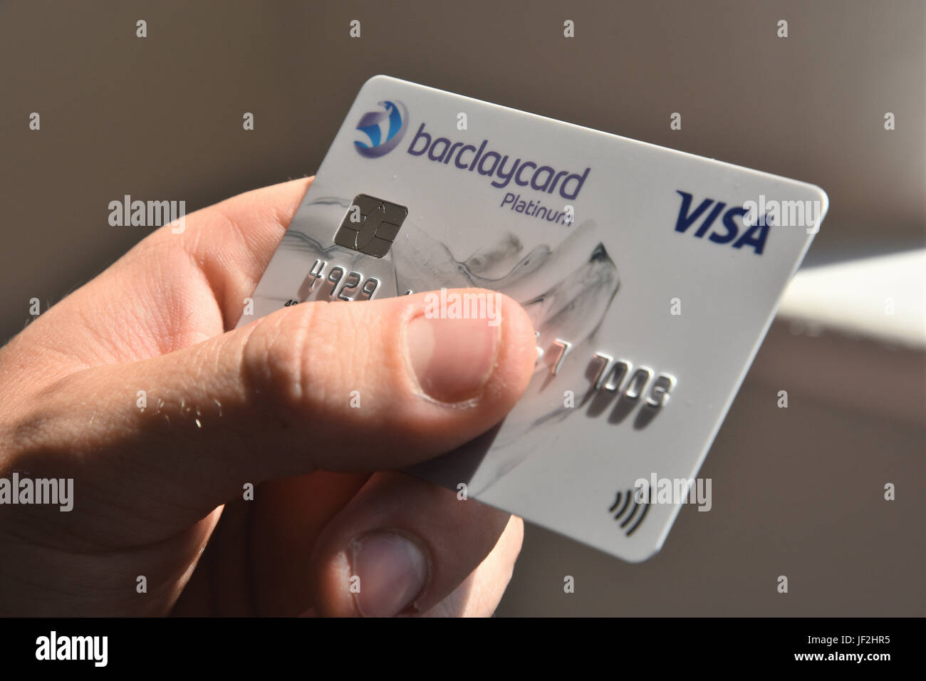 Close up of teenage boy holding a Barclaycard Visa credit card. Stock Photo