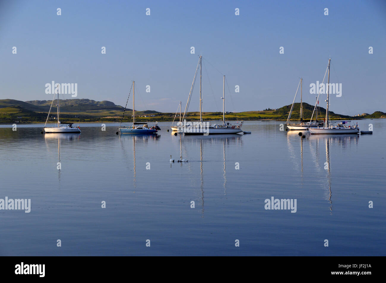 Five Sailing Boats Moored in Craighouse, Small Isles Bay  on the Isle of Jura in the Scottish Islands, Scotland UK. Stock Photo