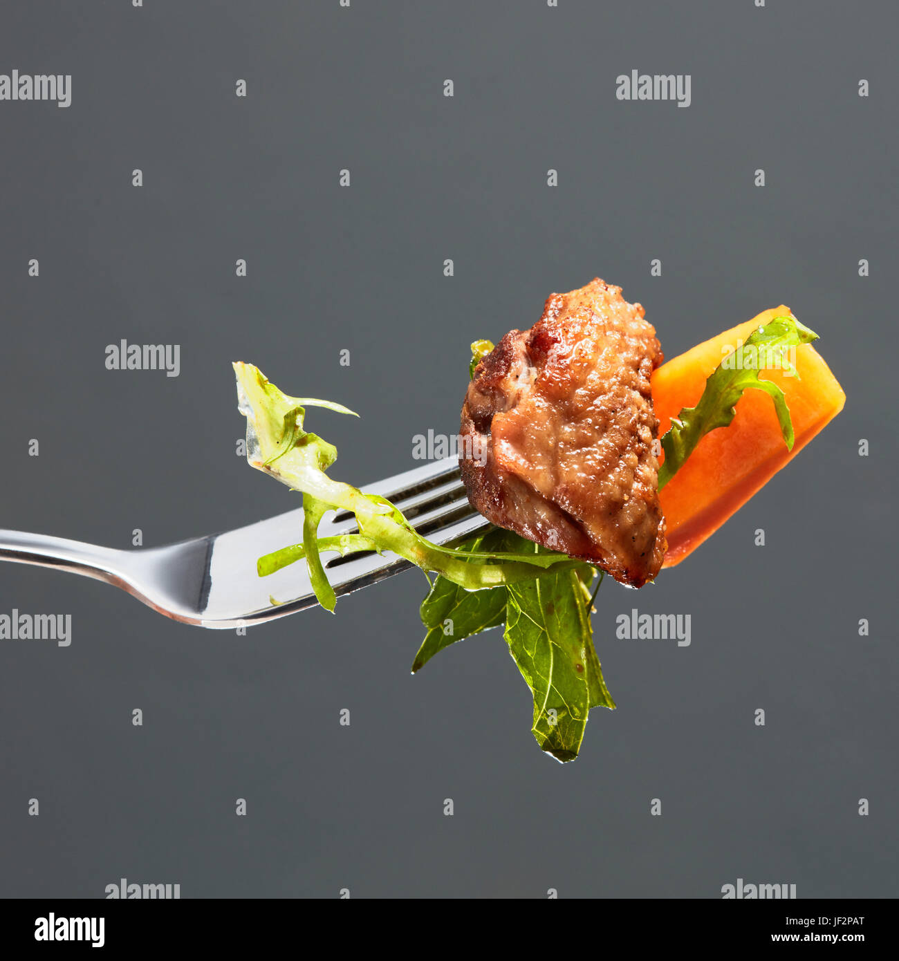 pumpkin, meat and salad on a fork Stock Photo
