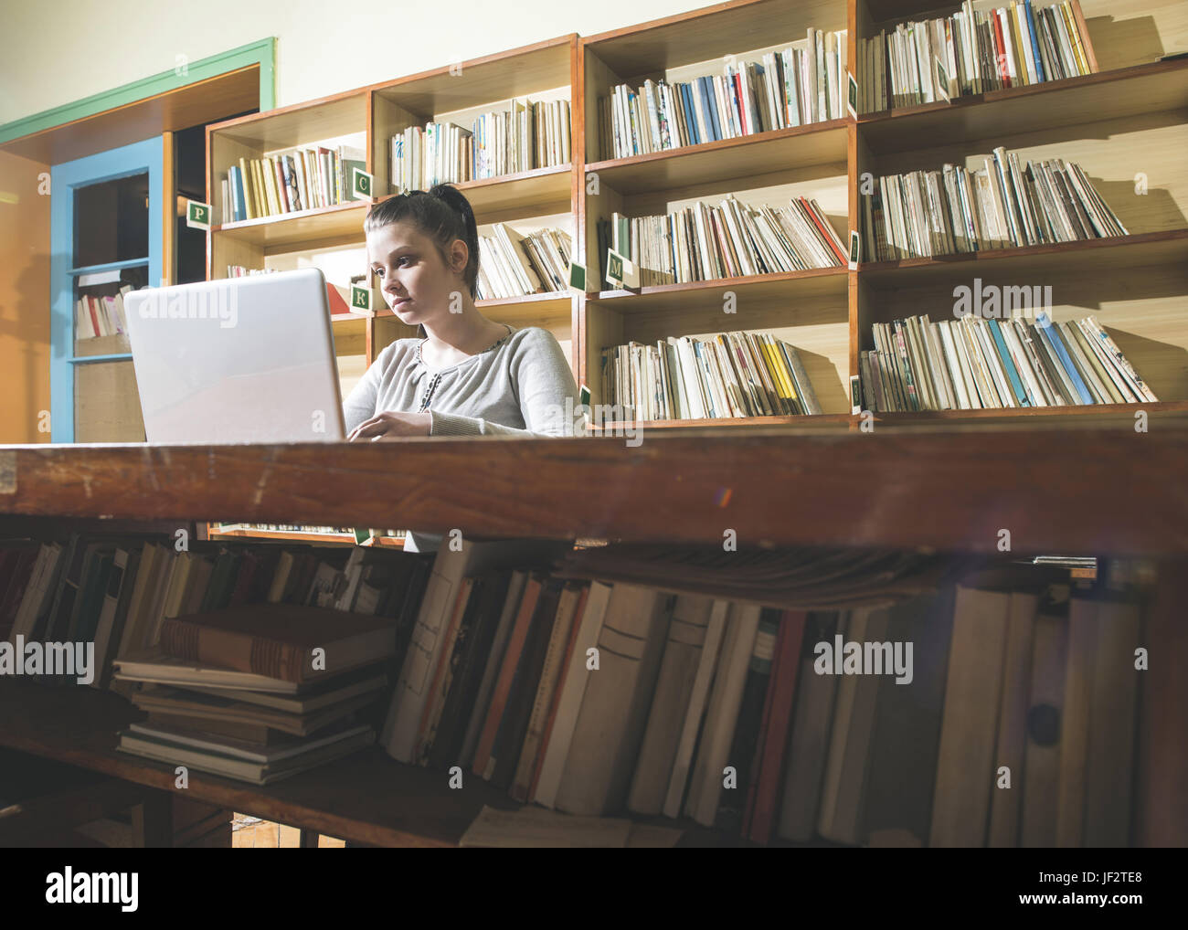 Student girl and laptop in a library Stock Photo - Alamy