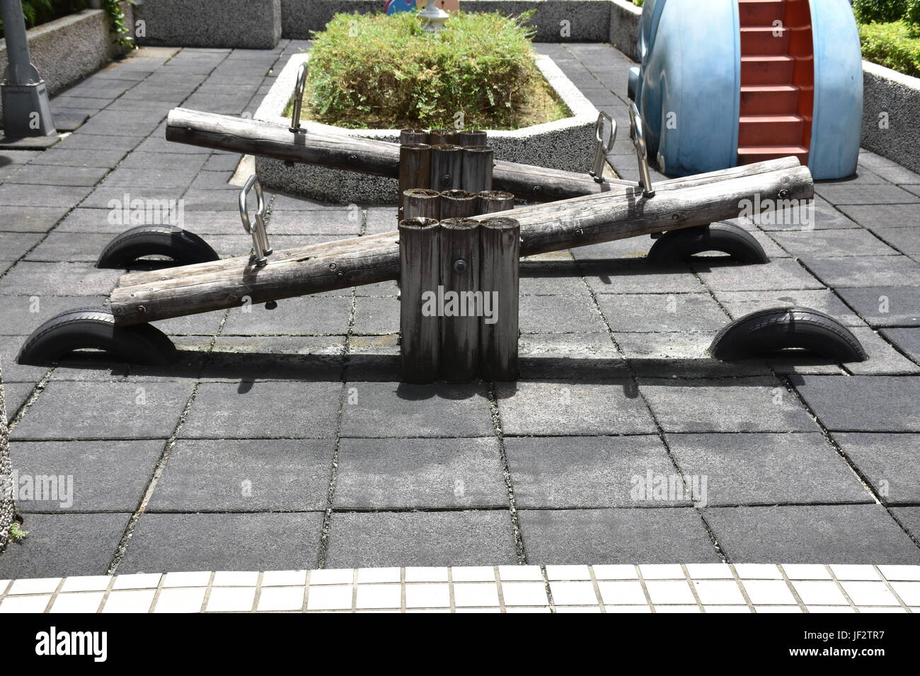 Children's see saw made from logs, in playground garden area. Stock Photo