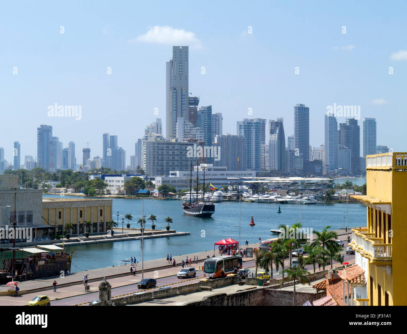 View of modern district of Bocagrande across water with sailing ship from rooftop in Plaza de los Coches, old town, Cartegena, Colombia Stock Photo