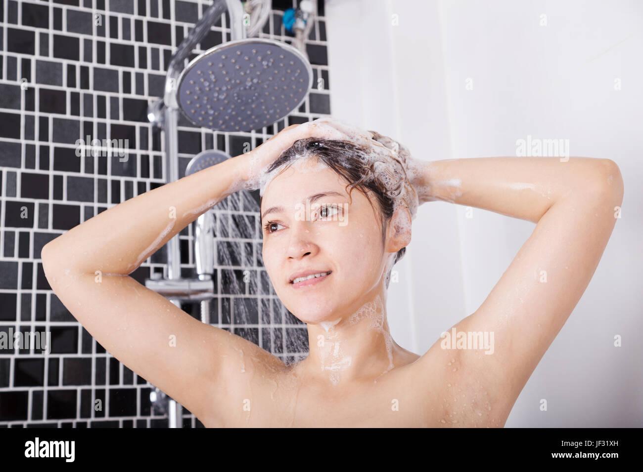 happy woman washing head with shampoo and the shower Stock Photo Alamy