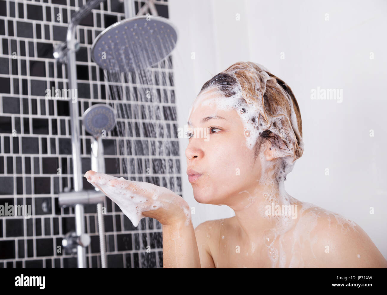 happy woman washing head with shampoo and the shower Stock Photo Alamy