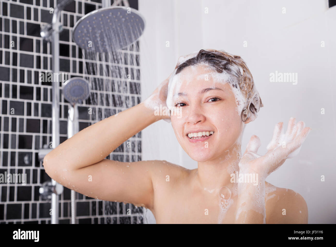 happy woman washing head with shampoo and the shower Stock Photo Alamy