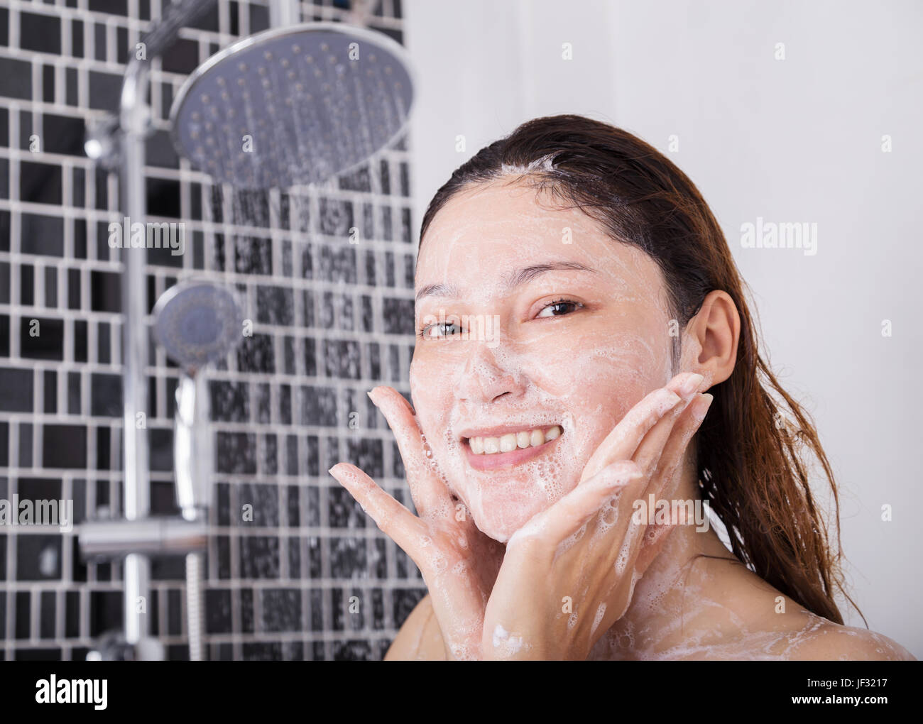 woman washing face in shower foaming in the bathroom Stock Photo Alamy