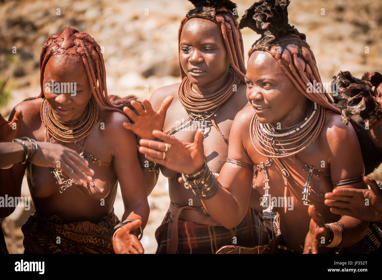 Traditional Himba women in typical dress in the Damaraland region of northern Namibia, in southern Africa. Stock Photo