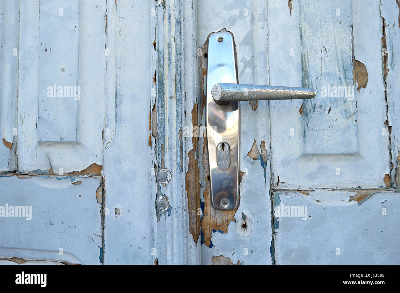 Closeup of a door knob in an old and deteriorated door Stock Photo
