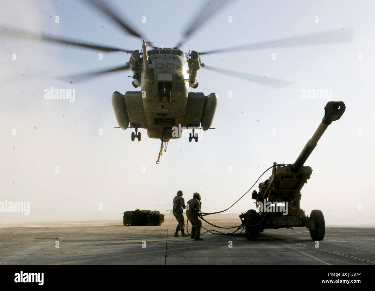061129-M-8213R-004 Marines prepare to attach a sling fastened to a M198 Medium Howitzer onto a U.S. Marine Corps CH-53E Super Stallion helicopter in Al Asad, Iraq, on Nov. 29, 2006, The Super Stallion, from Heavy Marine Helicopter Squadron 465, 3rd Marine Aircraft Wing (Forward), will airlift the howitzer to Barwana, Iraq. DoD photo by Gunnery Sgt. Michael Q. Retana, U.S. Marine Corps. (Released) Stock Photo