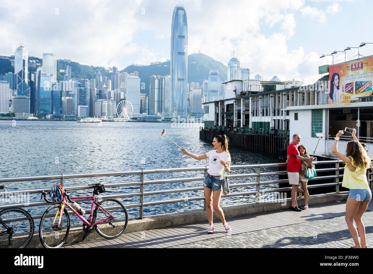 Caucasian tourists taking selfies visiting Tsim Sha Tsui, Hong Kong Stock Photo
