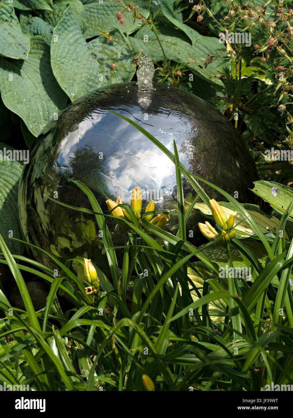 Small spherical metal globe garden fountain water feature Stock Photo