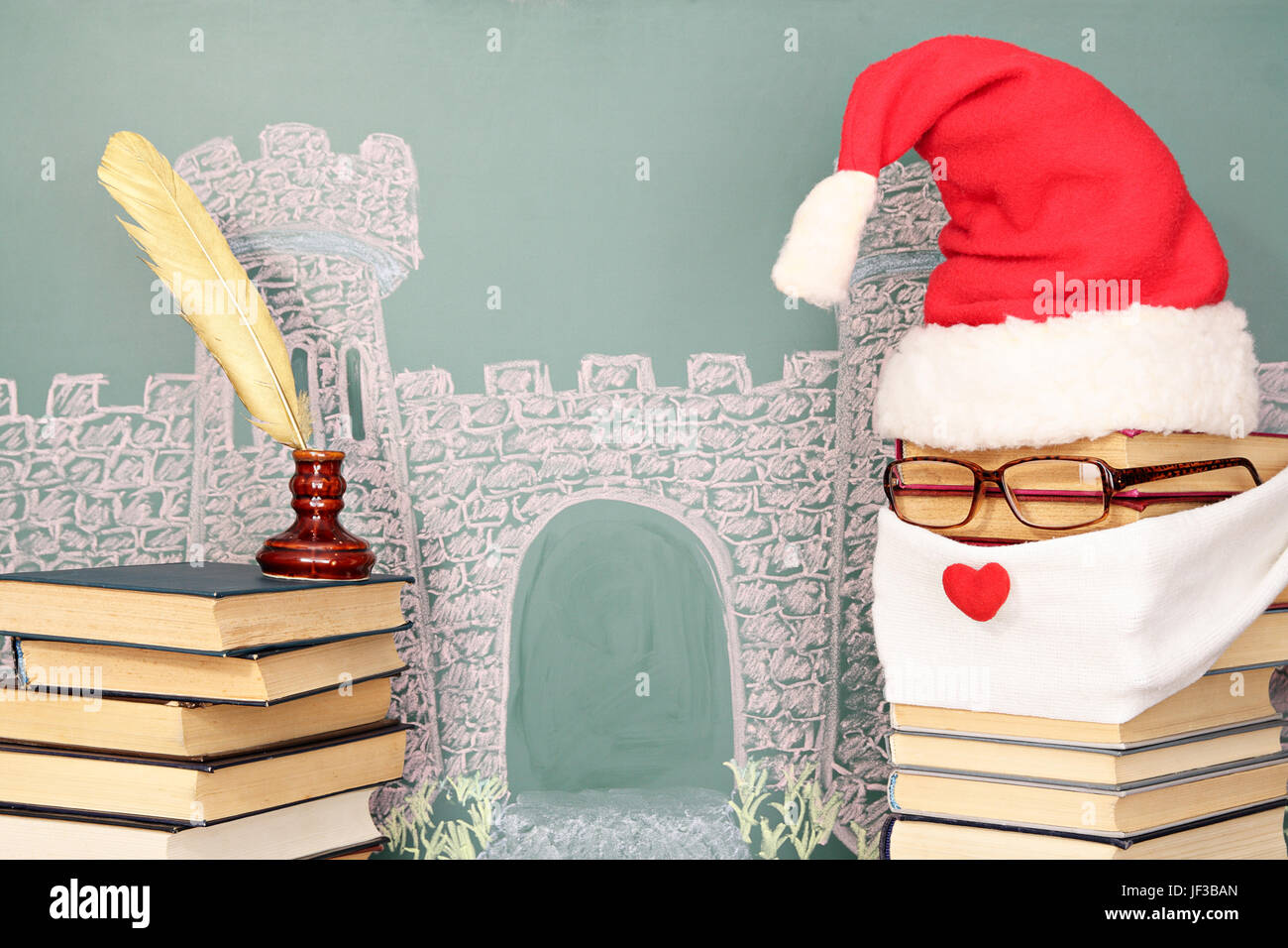 Unusual Santa Claus from books before blackboard with drawing chalk of castle Stock Photo