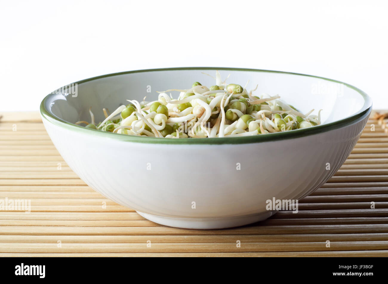A bowl of mung beansprouts on a bamboo placemat with copy space above.  Landscape (horizontal) orientation. Stock Photo