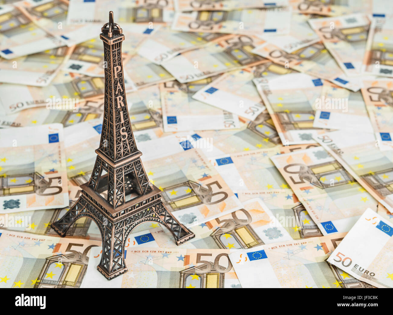 Travel budget concept with copy space. Eiffel Tower souvenir and vacation money. Savings for trip to France. Stock Photo