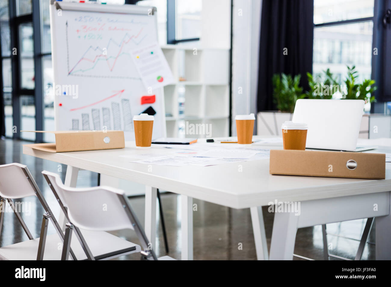 workplace with laptop, coffee paper cups in modern office Stock Photo ...