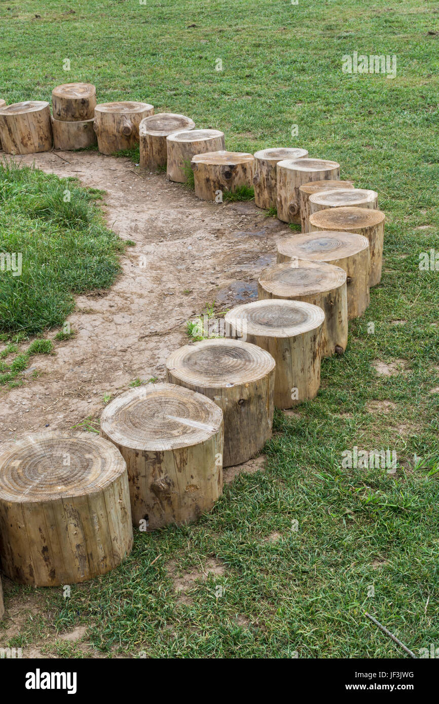 Log seating arranged round a campfire at an outdoor / environmental education centre for children (in Cornwall, UK). Stock Photo