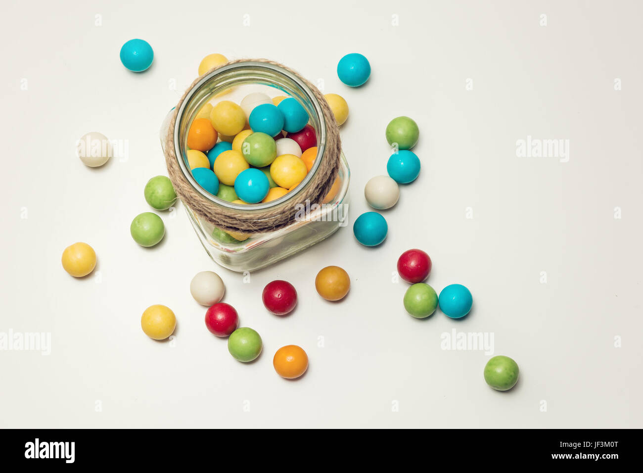 Colored chewing gum balls in container Stock Photo