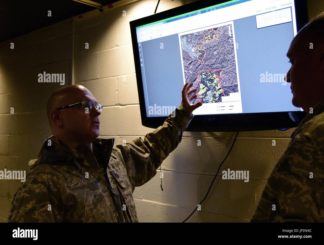 Tech. Sgt. Daron, a member of the 236th Intelligence Support, shows an airmen a map of the wild fires in east Tennessee on Jan. 7, 2017 a Berry Field Air National Guard base in Nashville, TN. The 236th IS provided valuable imagery and mapping support to the Tennessee Emergency Management Agency and other civilian agencies fighting the fires. (U.S.Air National Guard photo by Senior Airman Anthony Agosti) Stock Photo