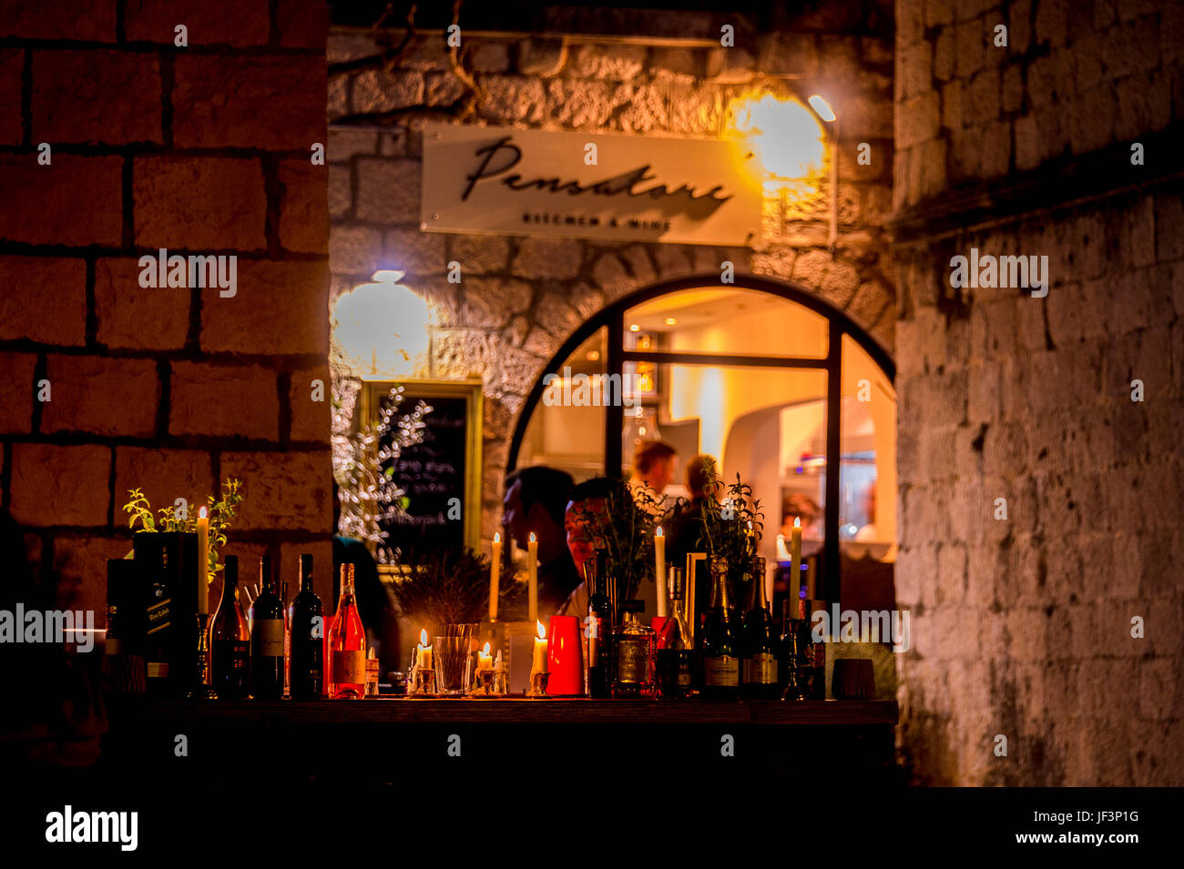 Night and the Old Town restaurants that line Zakerjan promenade on top of the East Town Wall in Old Town Korcula town, Croatia Stock Photo
