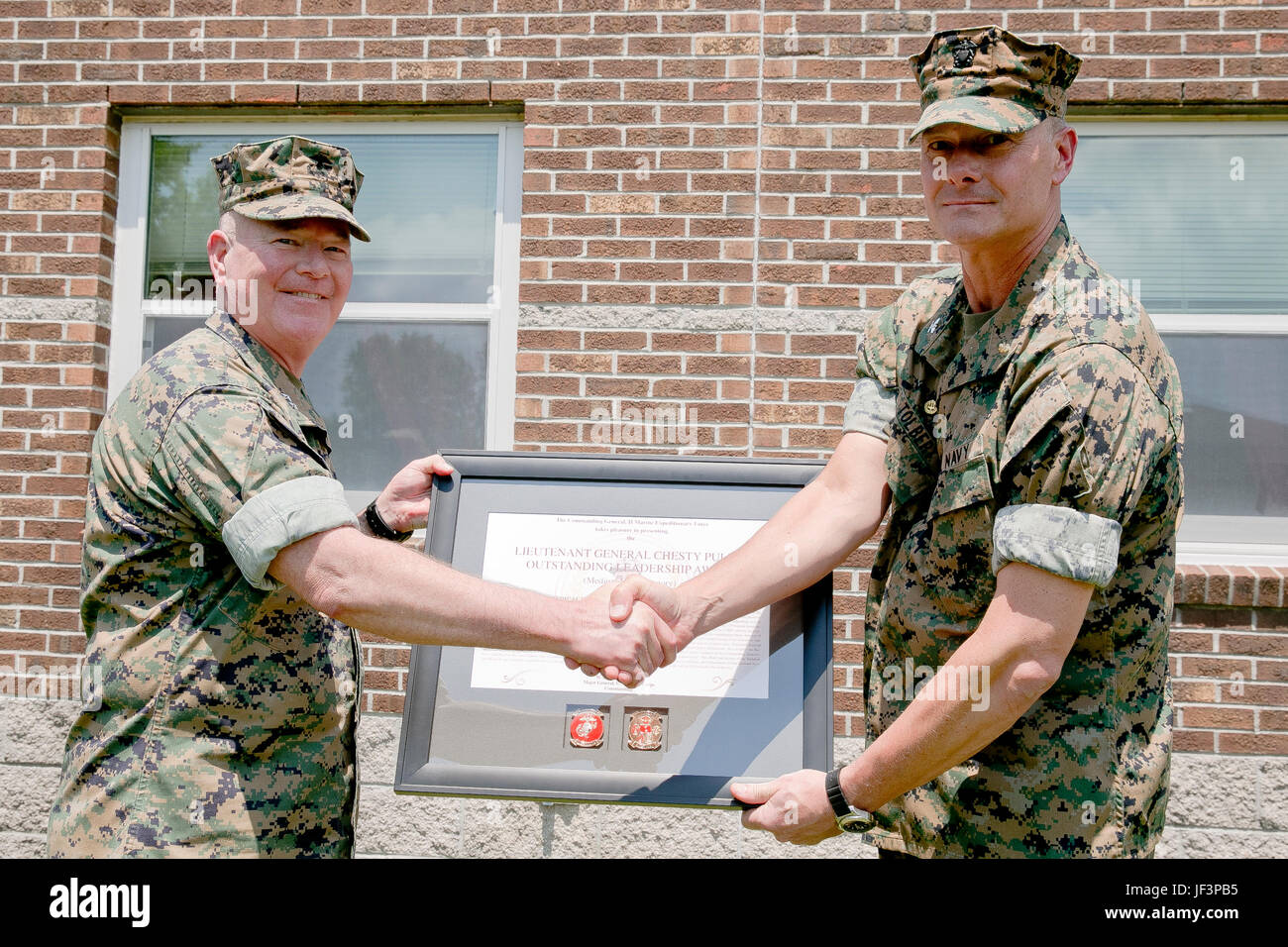 U.S. Marine Corps Maj. Gen. W. Lee Miller Jr., left, commanding general, II Marine Expeditionary Force (II MEF), shakes hands with U.S. Navy Capt. Brian Tolbert, commanding officer, 2nd Medical Battalion (2d MED BN), II MEF, after the battalion received the “Lt. Gen. Chesty Puller” Outstanding Leadership Award on Camp Lejeune, N.C., May 10, 2017. The battalion earned this award for exceptional professional ability, superior performance and dedication to supporting the mission of the II MEF. (U.S. Marine Corps photo by Sgt. Kelly L. Street) Stock Photo
