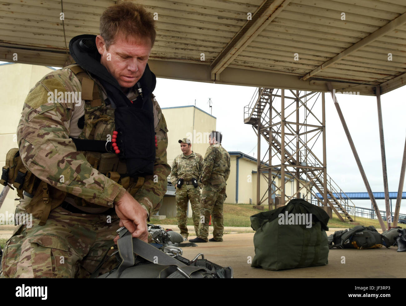 Senior Master Sgt. Andrew Hobbs, 181st Weather Flight superintendent, prepares to don his parachute equipment before a deliberate water drop into Lake Worth in Forth Worth, Texas, May 20, 2017. Hobbs is part of the Air Force Special Operations Weather Team, and as a member must undergo unique training to operate in hostile and denied territories to provide on-the-ground weather reporting. (Texas Air National Guard photo by Staff Sgt. Kristina Overton) Stock Photo