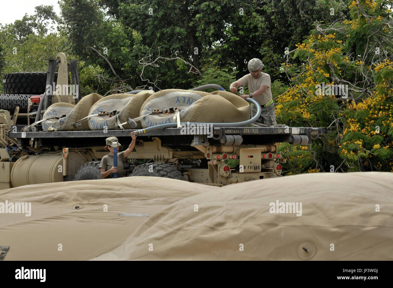 Army Sgt. Abdiel Colon, assigned to the 973rd Quartermaster Company from Ceiba, Puerto Rico, oversees the exchange of 1,500 gallons of water from five doughnut-shaped bladders, through the tactical water purification system, and into containers on the back of a flatbed truck in Brice Barracks, Belize, on May 24, 2017. The water is essential to the continued success of Beyond the Horizon 2017, a U.S. Army South partnership exercise with the Government of Belize that consists of five construction projects and three health care events in communities across Belize (U.S. Army photo by Spc. Nathanie Stock Photo