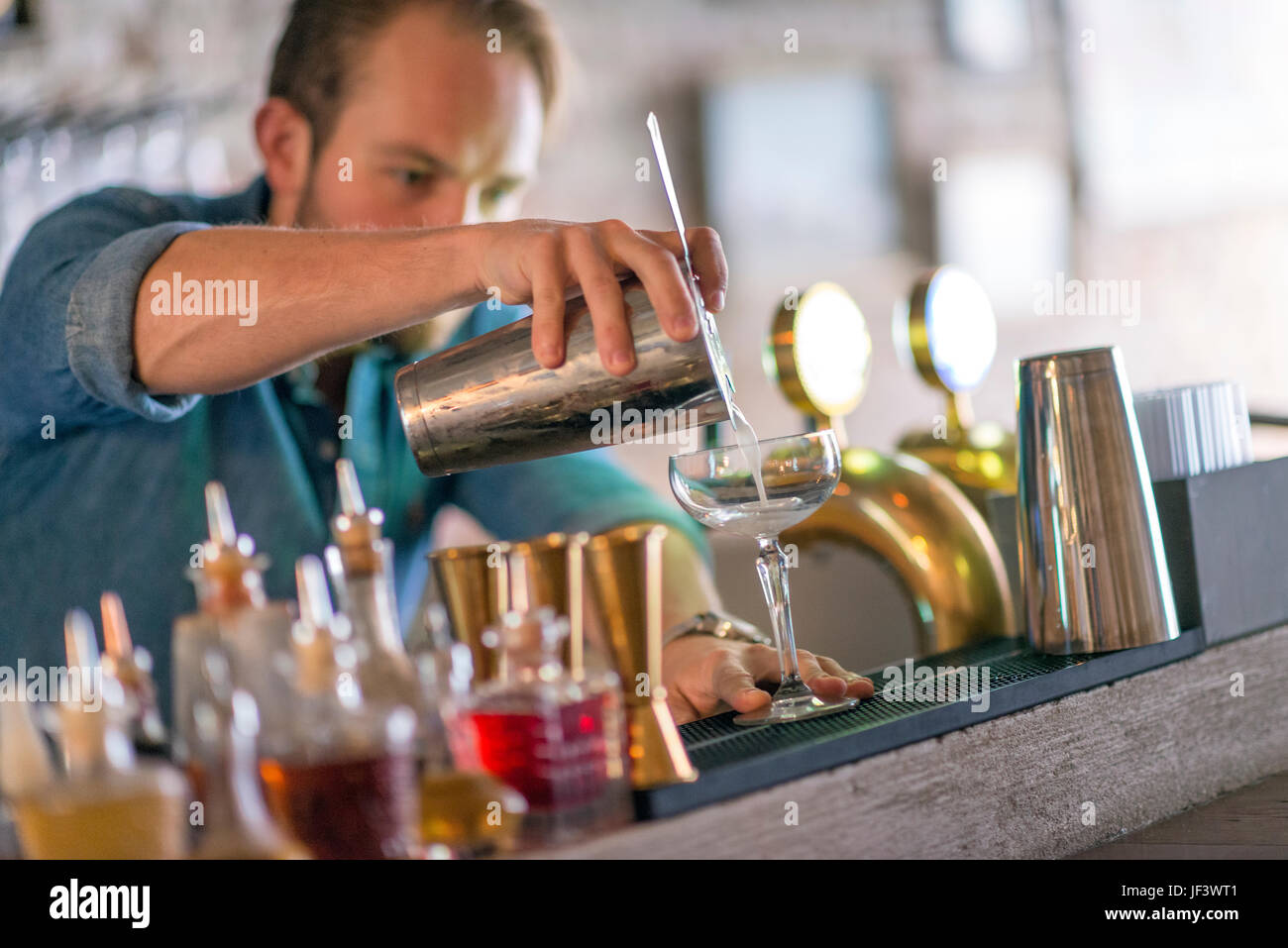 Barman preparing drink behind bar Stock Photo Alamy